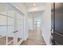Welcoming entryway with light wood floors, white trim, and view to the living spaces beyond at 14131 Bunny Hop Ln, Parker, CO 80134