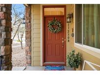 Inviting front door with a decorative wreath and a colorful 'Welcome' mat at 11230 Osage Cir # B, Northglenn, CO 80234