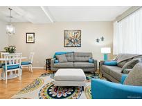 Inviting living room features a plush gray sofa, ottoman, and colorful area rug, creating a comfortable and stylish space at 11230 Osage Cir # B, Northglenn, CO 80234