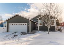 Gray exterior house with white garage door and snowy front yard at 7980 Larkspur Cir # 225, Frederick, CO 80530