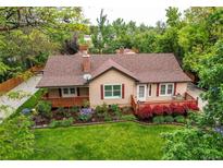 Charming single Gathering home featuring a covered front porch and beautifully landscaped front yard at 7785 W 5Th Ave, Lakewood, CO 80226