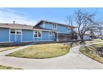 Inviting blue townhome with a well-manicured lawn and charming walkway on a bright, sunny day at 246 S Newark Cir, Aurora, CO 80012