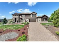 Beautiful two-story home boasts a brick driveway, manicured lawn, and mature landscaping at 5623 Raintree Dr, Parker, CO 80134