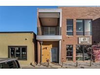 Modern brick exterior with a balcony and street-level storefront or entrance at 4258 Tennyson St # 104, Denver, CO 80212