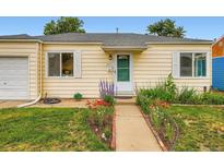 Charming yellow home with a well-manicured lawn and flower-lined walkway leading to a bright green front door at 1237 Tamarac St, Denver, CO 80220