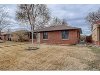 Charming brick home featuring a well-maintained front yard and mature trees at 2285 Ironton St, Aurora, CO 80010