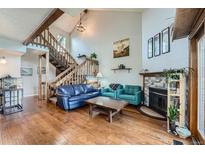 Cozy living room featuring wood floors, exposed beams, fireplace, and a staircase at 10806 W Evans Ave # 5, Lakewood, CO 80227
