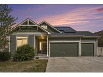 Charming two-story home featuring a three-car garage and well-manicured lawn at sunset at 4873 Cathay Ct, Denver, CO 80249