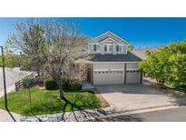Beautiful two-story home with a three-car garage, lush lawn and mature shade tree at 7506 Chipmunk Pl, Littleton, CO 80125