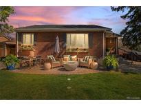 Cozy brick patio with comfortable outdoor seating and a modern fire pit, perfect for relaxing evenings at 6925 W 27Th Ave, Wheat Ridge, CO 80033