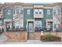 Inviting two-story townhome featuring a quaint front porch, updated paint, and a welcoming entrance at 9369 Longs Peak Dr, Henderson, CO 80640