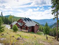 Beautiful exterior of home with solar panels, nestled in the mountains at 76 Raven Ridge Rd, Idaho Springs, CO 80452