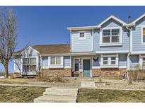 Charming two-story townhome with brick accents, manicured lawn, and inviting entrance at 18865 E 57Th Ave # B, Denver, CO 80249