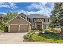 Beautiful two-story home with a well-maintained lawn, a two car garage, and beautiful landscaping at 2141 Weatherstone Cir, Highlands Ranch, CO 80126