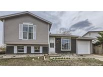 Charming two-story home with a brick and vinyl exterior and well-maintained front yard at 2311 E 96Th Way, Thornton, CO 80229