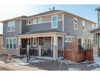 Charming two-story home with gray siding, brick accents, and a covered front porch, offering a welcoming curb appeal at 431 Courtfield Way, Castle Pines, CO 80108