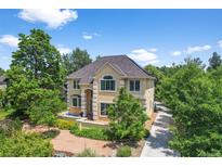 Inviting two-story home with lush landscaping, a pathway, and an arched entryway, creating an elegant and welcoming curb appeal at 1564 S Uinta Way, Denver, CO 80231