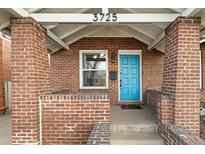 Charming brick home with a striking blue front door and covered porch at 3725 Federal Blvd, Denver, CO 80211