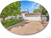 Charming two-story home features a well-maintained lawn, mature trees, and a two-car garage at 13246 Deneb Dr, Lone Tree, CO 80124