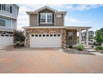 Charming two-story home with a two-car garage, stone accents, and a brick driveway at 3934 N Quatar Ct, Aurora, CO 80019