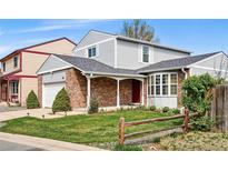 Charming two-story home with brick accents, a well-maintained lawn, and a delightful bay window at 466 S Kingston Cir, Aurora, CO 80012