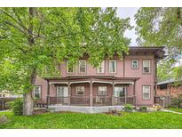 Inviting exterior of a two-story home with a charming front porch, lush trees, and vibrant green lawn at 820 Kimbark St # B, Longmont, CO 80501