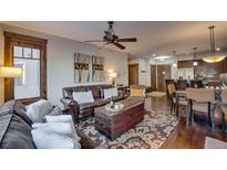 Spacious living room with leather sofas, a stone fireplace, and large windows at 600 Columbine Rd # 5207, Breckenridge, CO 80424