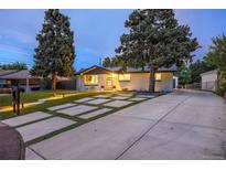 Charming home featuring a modern driveway design and beautiful curb appeal with manicured lawn and mature trees at 1260 Hoyt St, Lakewood, CO 80215