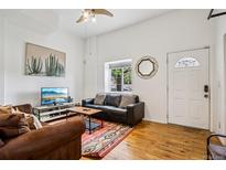 Cozy living room with hardwood floors, comfortable seating, and a decorative rug at 915 26Th St, Denver, CO 80205