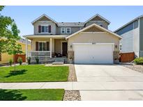 Attractive two-story home featuring a manicured lawn and a two-car garage with stone accents at 16975 Melody Dr, Broomfield, CO 80023