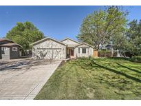 Charming single-story home with a well-manicured lawn, mature trees, and an attached two-car garage at 1367 Teller St, Lakewood, CO 80214