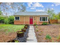 Charming brick home featuring a red front door, meticulous landscaping, and a well-maintained walkway at 2870 Pontiac St, Denver, CO 80207