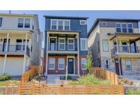 Charming exterior of a three-story home with a blue facade, brick accents, and a fenced front yard at 11063 Shining Star Cir, Parker, CO 80134