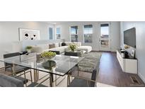 Bright, open living area with modern furnishings and a glass dining table offers space and style at 11063 Shining Star Cir, Parker, CO 80134