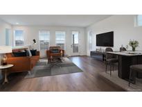 Cozy living room featuring hardwood floors, modern furniture, and plenty of natural light at 11063 Shining Star Cir, Parker, CO 80134