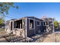 Gray bungalow with rock landscaping, white framed windows, and light-colored patio; a quaint home with modern touches at 6190 Ivy St, Commerce City, CO 80022