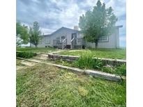 Charming single-story home featuring a front deck, well-maintained lawn, and inviting curb appeal at 47904 Dartmouth Ave, Bennett, CO 80102