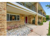 Inviting townhouse exterior featuring brick facade and a charming red front door at 6727 S Race St, Centennial, CO 80122