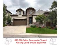 Charming two-story home features a stone facade, well-manicured lawn, and attached two-car garage at 6875 Northstar Ct, Castle Rock, CO 80108
