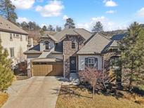 Charming stone and stucco home with a two-car garage and a well-maintained lawn and manicured landscaping at 6875 Northstar Ct, Castle Rock, CO 80108