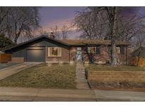 Charming brick home with a well-maintained lawn, updated windows, and a neutral color palette at 3761 W Saratoga Ave, Littleton, CO 80123