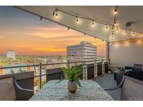 Balcony with outdoor seating features beautiful sunset views and string lighting at 800 N Washington St # 804, Denver, CO 80203