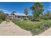 Charming home with a well-maintained lawn and a striking orange front door at 1271 Uinta St, Denver, CO 80220