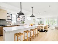 Bright, open kitchen featuring a large island with seating, modern appliances, and stylish decor at 2736 N Clay St, Denver, CO 80211