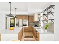 Modern kitchen featuring a large island, wood cabinets, and stainless steel appliances at 2736 N Clay St, Denver, CO 80211