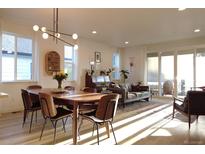 Open concept living and dining area with large windows, stylish furnishings, and abundant light at 5211 Routt Ct, Arvada, CO 80002