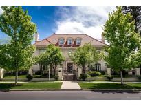 Stately home featuring manicured lawn, mature trees, a gated entrance and a red tile roof at 930 E 7Th Ave, Denver, CO 80218