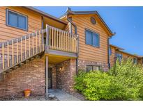 Charming exterior showcasing brick facade, private balcony, and lush landscaping at 2223 S Buckley Rd # 102, Aurora, CO 80013
