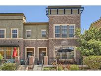 Charming brick townhome with a cozy front patio and manicured landscaping at 9486 Elmhurst Ln # D, Highlands Ranch, CO 80129