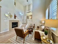 Inviting living room features a cozy fireplace, wood floors, and an open staircase to the second floor at 7777 E 23Rd Ave # 401, Denver, CO 80238